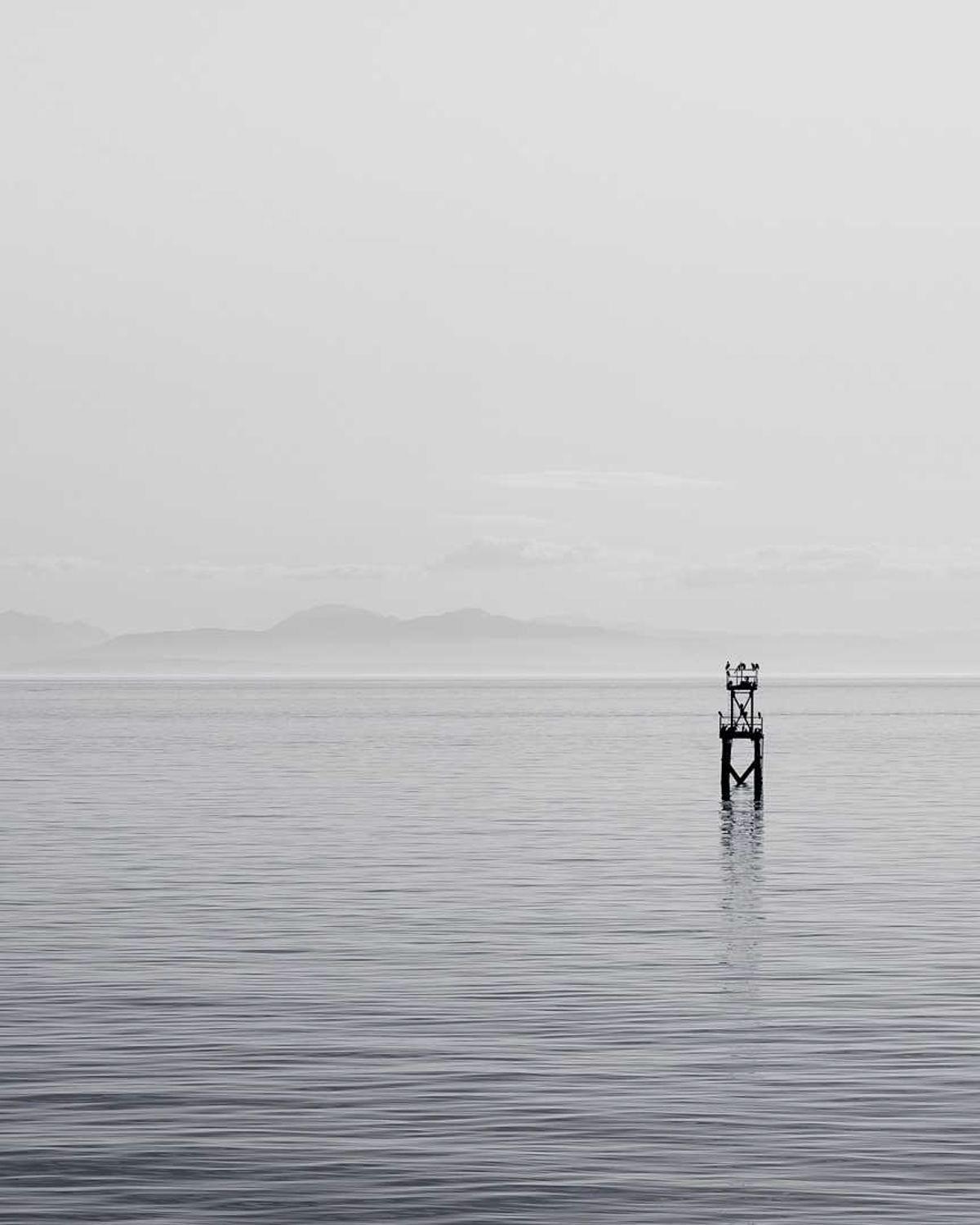 A lone figure standing in still, pale water